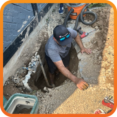 person in dug out ditch to make repair